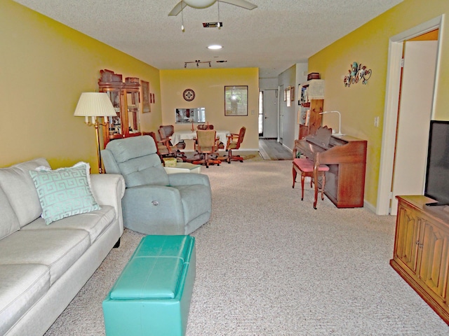 living room with ceiling fan and a textured ceiling