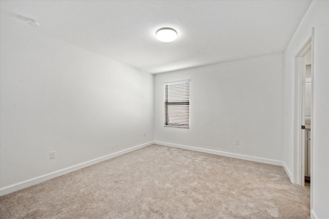 spare room featuring light colored carpet