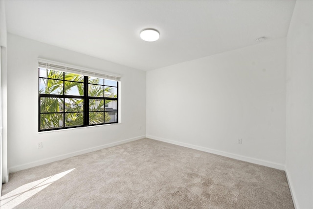 spare room featuring light colored carpet