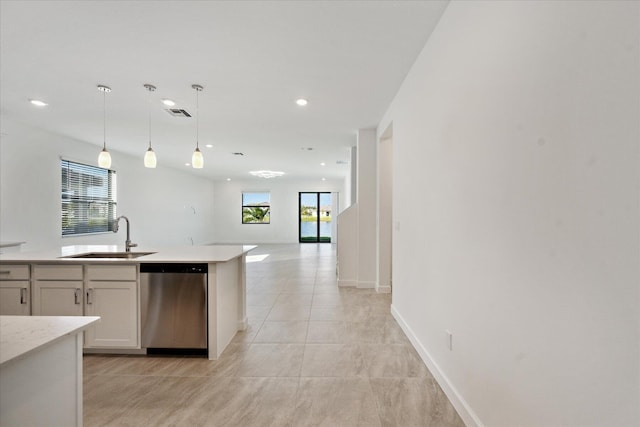 kitchen with decorative light fixtures, stainless steel dishwasher, white cabinetry, and sink