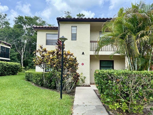 view of front of house featuring a front yard and a balcony