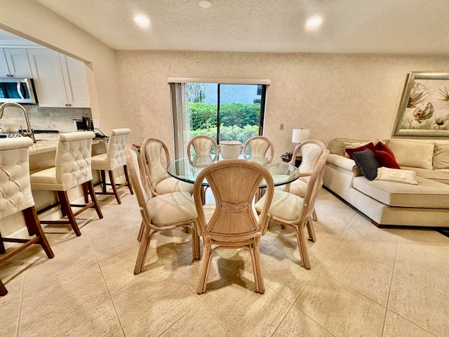 dining area featuring light tile patterned floors and a textured ceiling