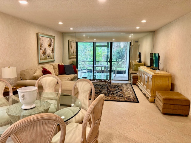 living room with light tile patterned floors, a textured ceiling, and expansive windows