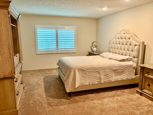 bedroom with light carpet and a textured ceiling