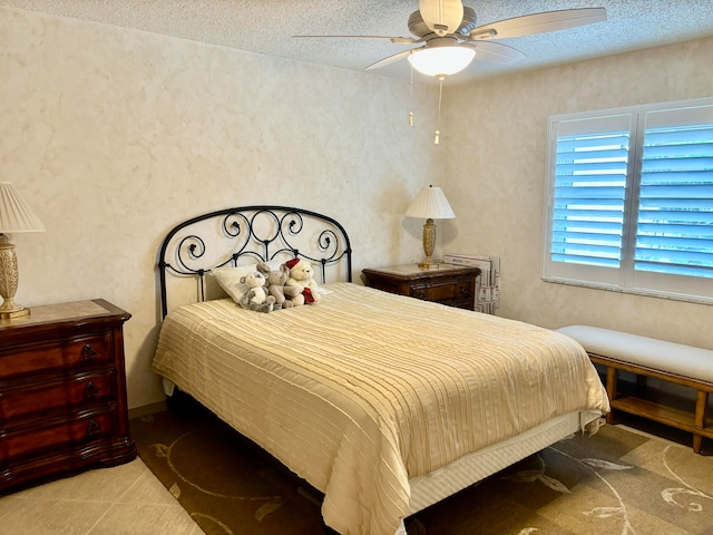 bedroom with ceiling fan and a textured ceiling