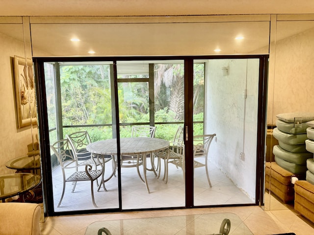 doorway with light tile patterned floors and a wealth of natural light