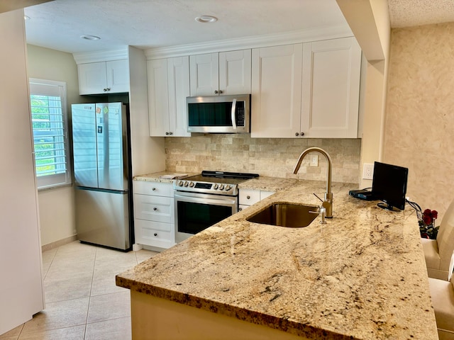 kitchen featuring light stone countertops, sink, white cabinets, and stainless steel appliances