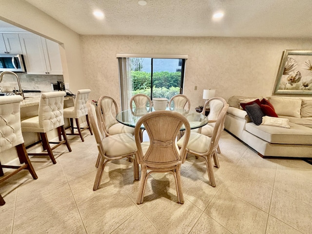 tiled dining space featuring a textured ceiling