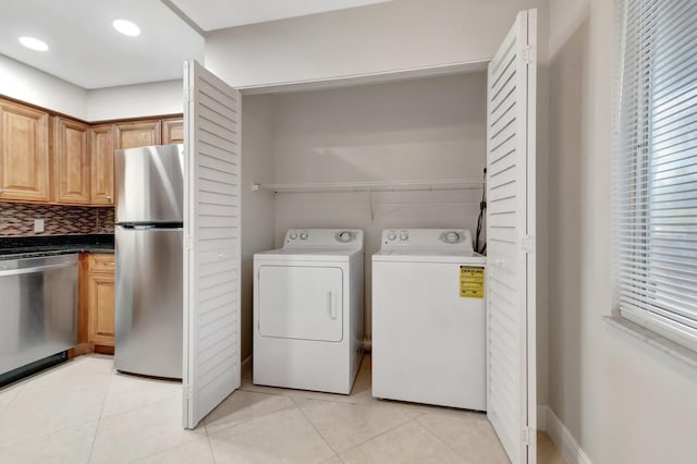 laundry room with independent washer and dryer and light tile patterned flooring