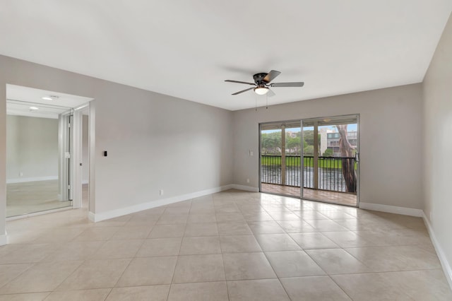 tiled spare room featuring ceiling fan