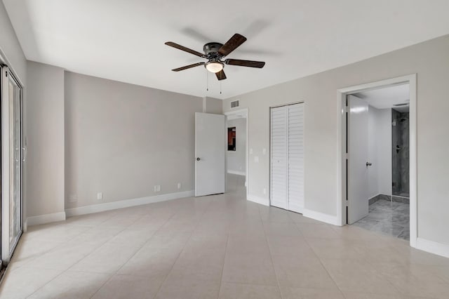 unfurnished bedroom with ceiling fan, light tile patterned floors, and multiple closets