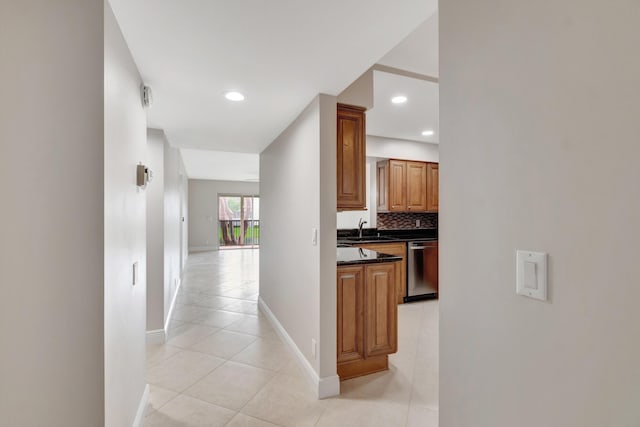 corridor featuring light tile patterned flooring and sink