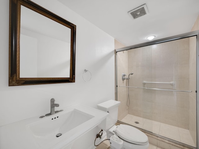 bathroom with toilet, a stall shower, visible vents, and a sink