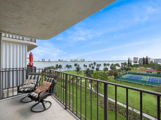 balcony featuring a view of city, a water view, and a tennis court