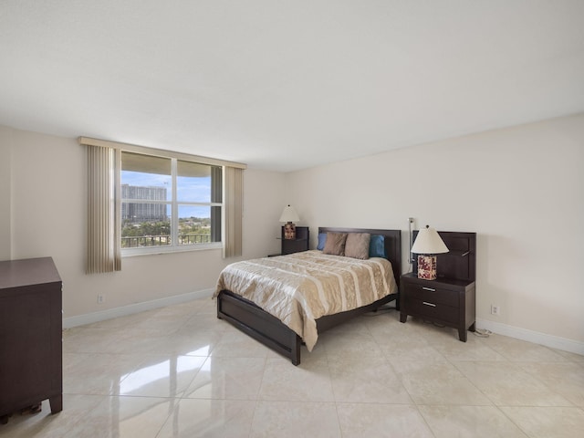 bedroom with light tile patterned floors and baseboards