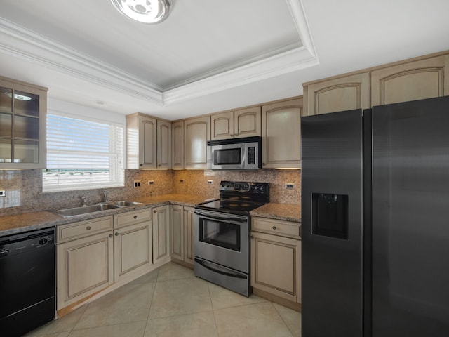 kitchen with a raised ceiling, glass insert cabinets, appliances with stainless steel finishes, light brown cabinets, and a sink