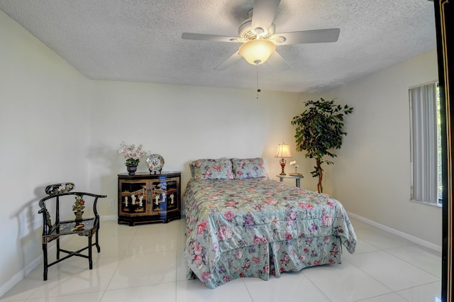 bedroom featuring tile patterned floors, ceiling fan, and a textured ceiling