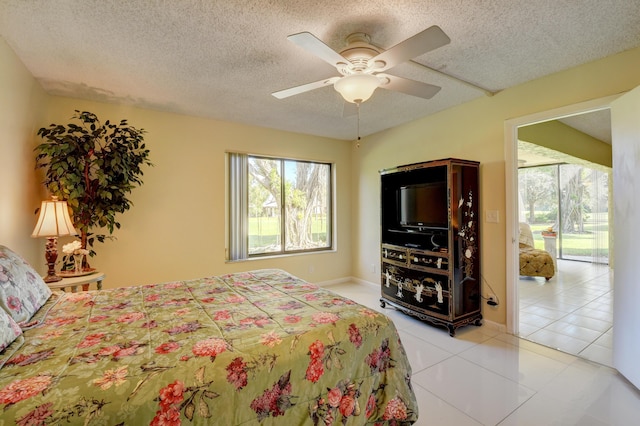 tiled bedroom with access to exterior, ceiling fan, and a textured ceiling