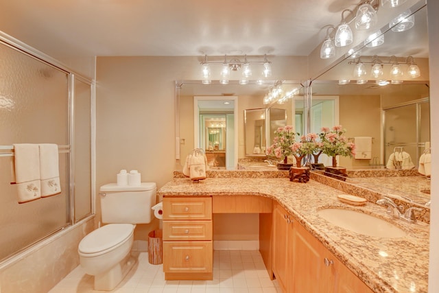 full bathroom featuring tile patterned flooring, vanity, toilet, and shower / bath combination with glass door