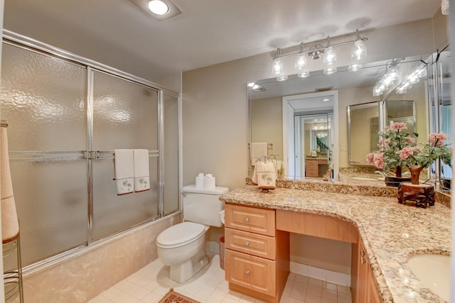 full bathroom featuring toilet, vanity, tile patterned floors, and bath / shower combo with glass door