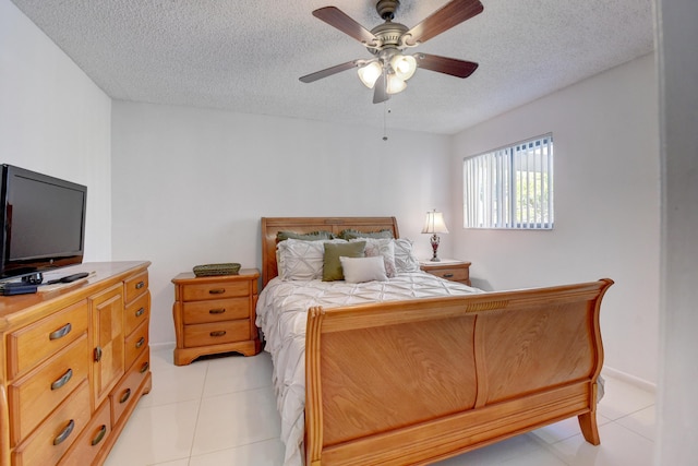 tiled bedroom with a textured ceiling and ceiling fan