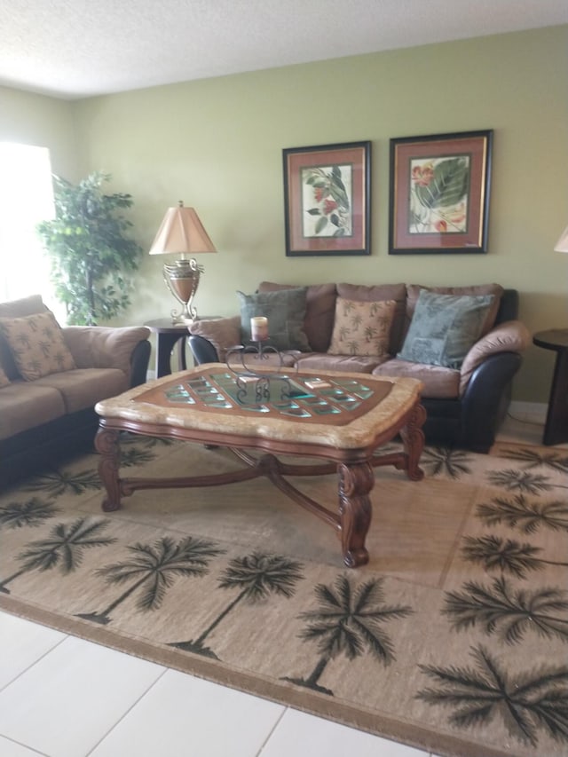 tiled living room featuring a textured ceiling