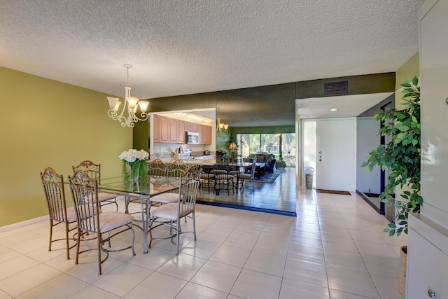 tiled dining area featuring a textured ceiling and a notable chandelier