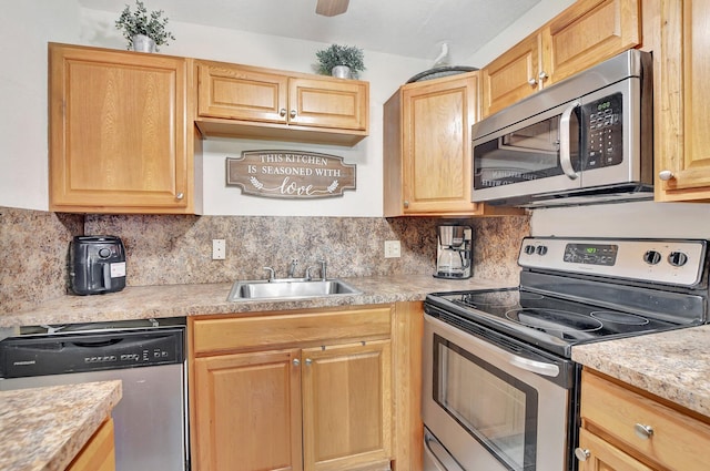 kitchen featuring light brown cabinets, stainless steel appliances, backsplash, and sink