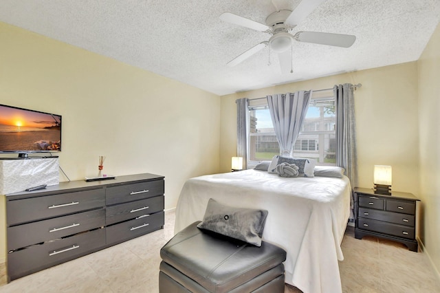 bedroom featuring a textured ceiling, ceiling fan, and light tile floors