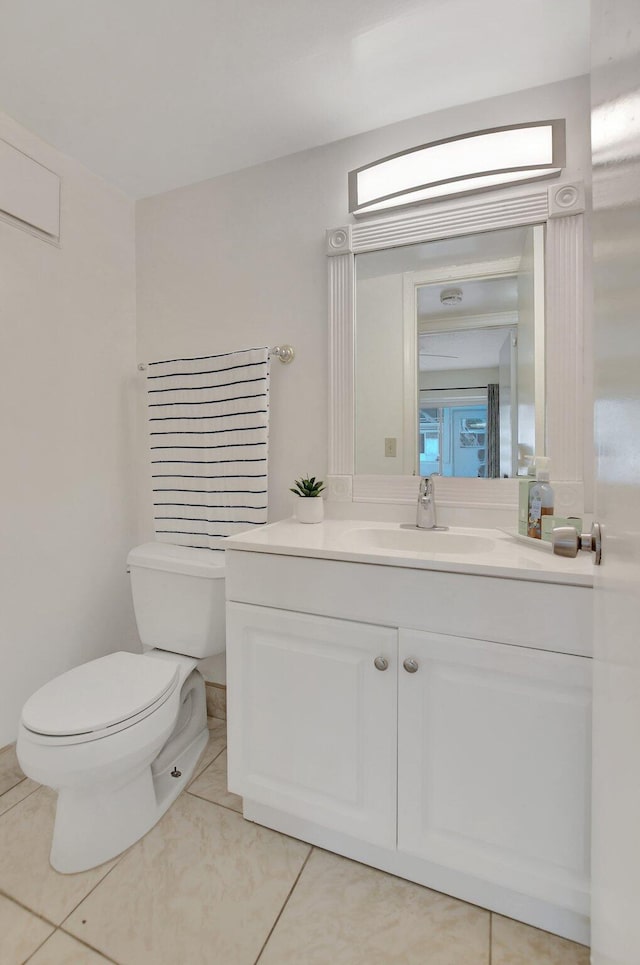 bathroom with vanity with extensive cabinet space, toilet, and tile floors