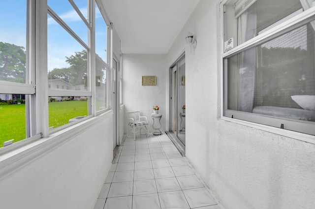 corridor with a healthy amount of sunlight and light tile floors