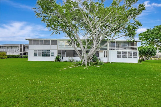 back of house featuring a sunroom and a yard