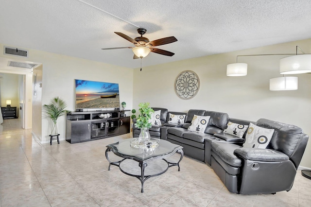 tiled living room with ceiling fan and a textured ceiling