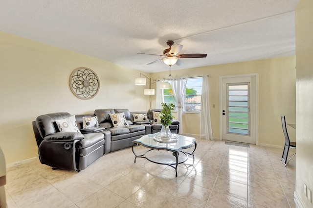 tiled living room featuring ceiling fan and a textured ceiling