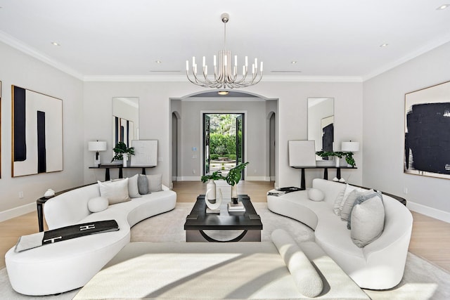 living room featuring a notable chandelier, ornamental molding, and light hardwood / wood-style flooring