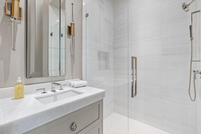 bathroom featuring a shower with shower door and vanity