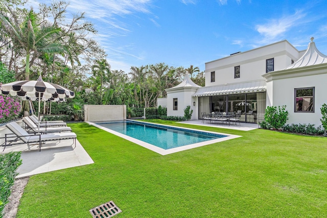 view of swimming pool featuring a patio area and a lawn