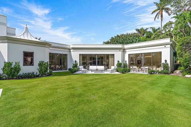 rear view of property with a patio and a lawn