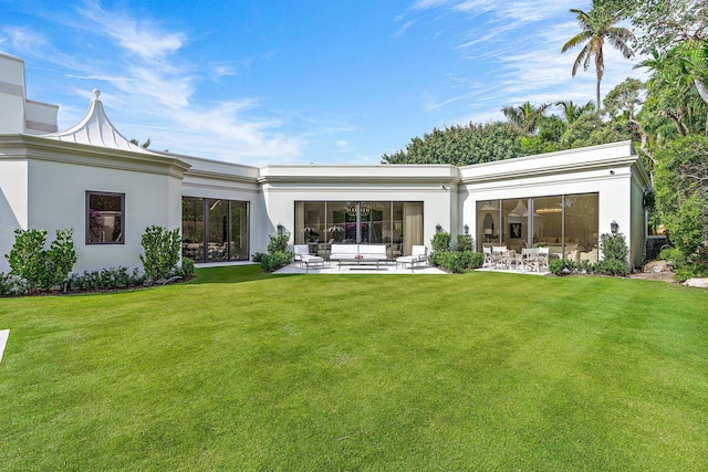 rear view of house featuring outdoor lounge area, a patio area, and a lawn