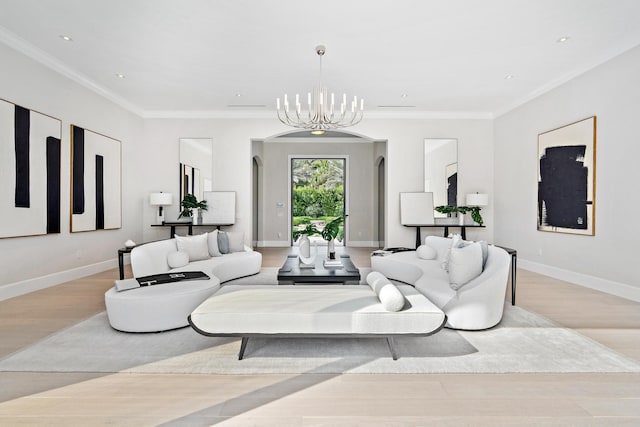 living room with a notable chandelier, ornamental molding, and light hardwood / wood-style floors