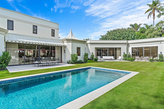 rear view of house featuring a patio, outdoor lounge area, and a yard