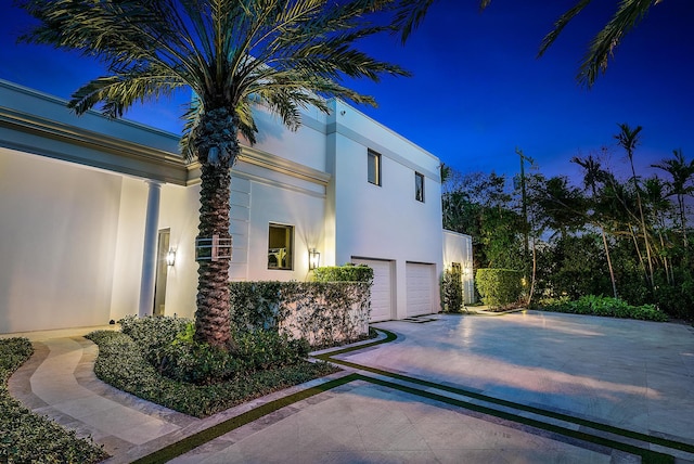 property exterior at twilight featuring a garage