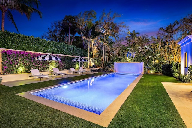 view of swimming pool featuring a yard and a patio area