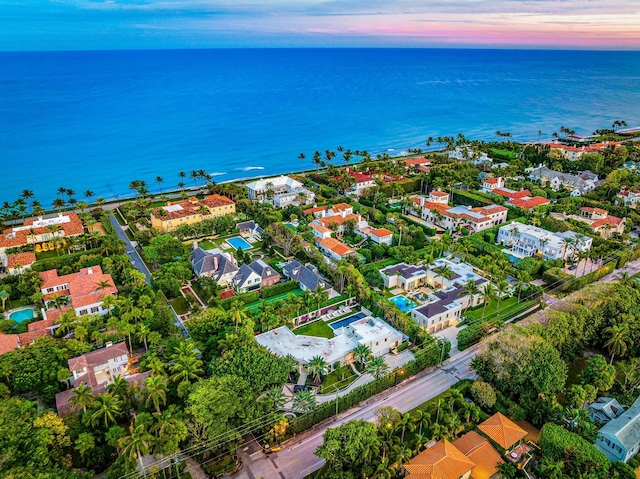 aerial view at dusk featuring a water view