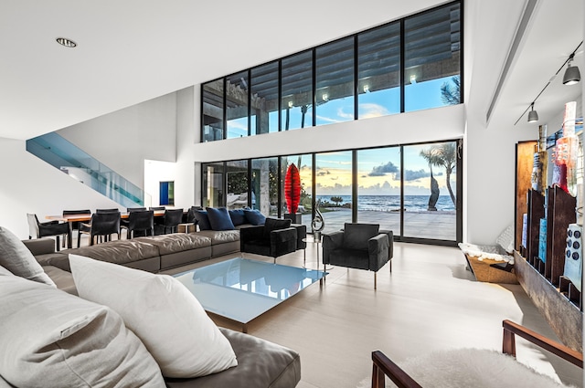 living room with a water view and a high ceiling