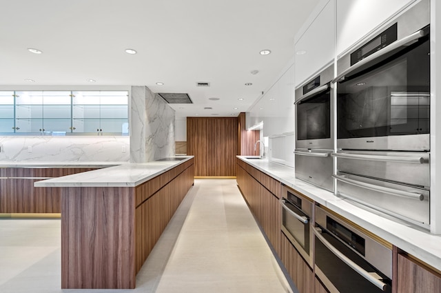 kitchen featuring white cabinetry, sink, and backsplash