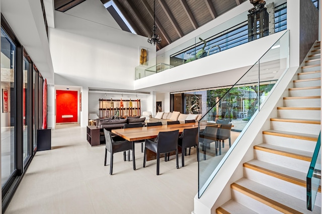 dining room featuring an inviting chandelier, high vaulted ceiling, and beamed ceiling