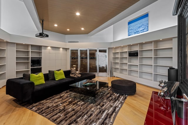 living room featuring wood-type flooring, a towering ceiling, and wooden ceiling