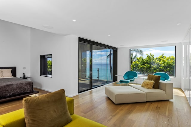 bedroom with expansive windows, access to exterior, and light hardwood / wood-style flooring