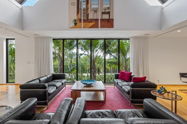 living room with a towering ceiling and a skylight